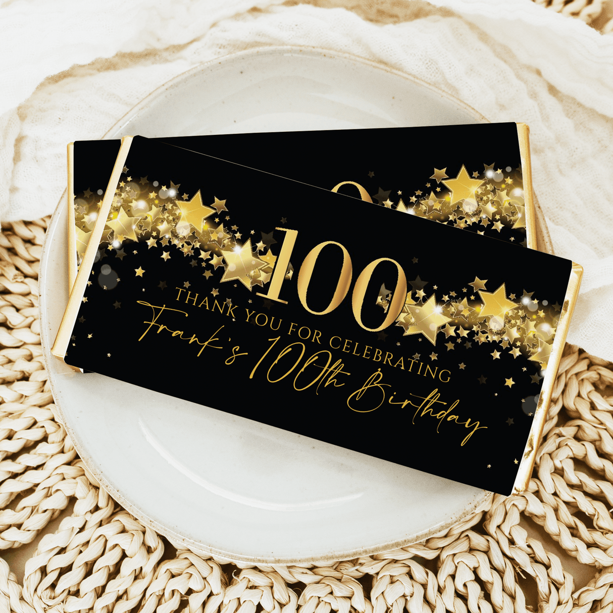 Black 100th birthday chocolate bar wrapper with gold stars and “Thanks for celebrating”