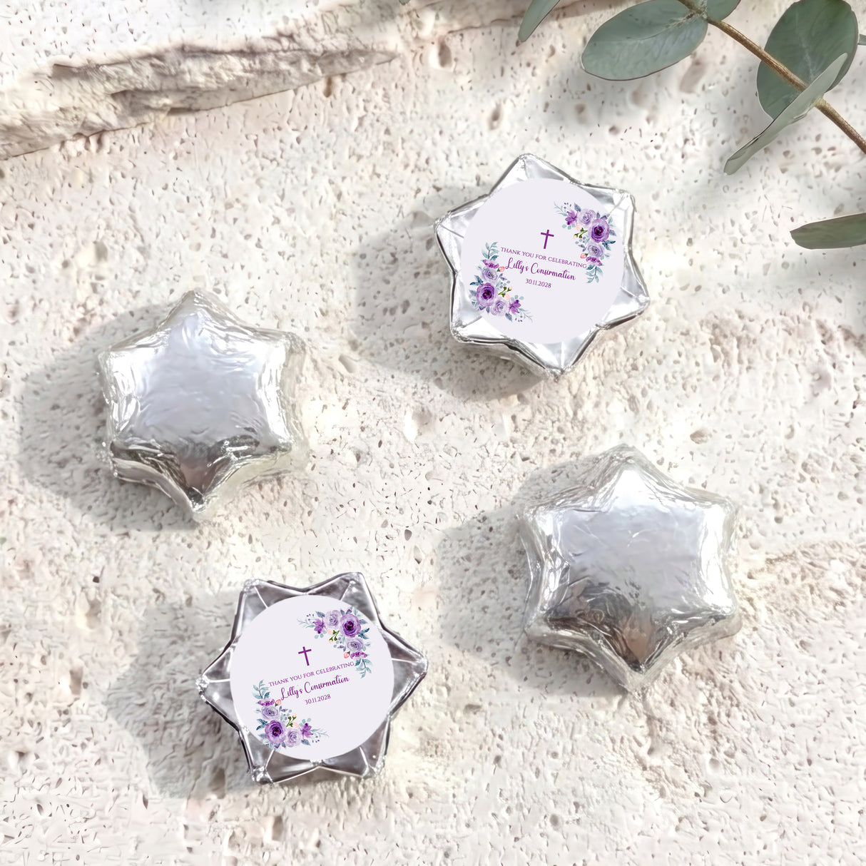 Silver foil-covered chocolate stars with round confirmation label and purple floral cross