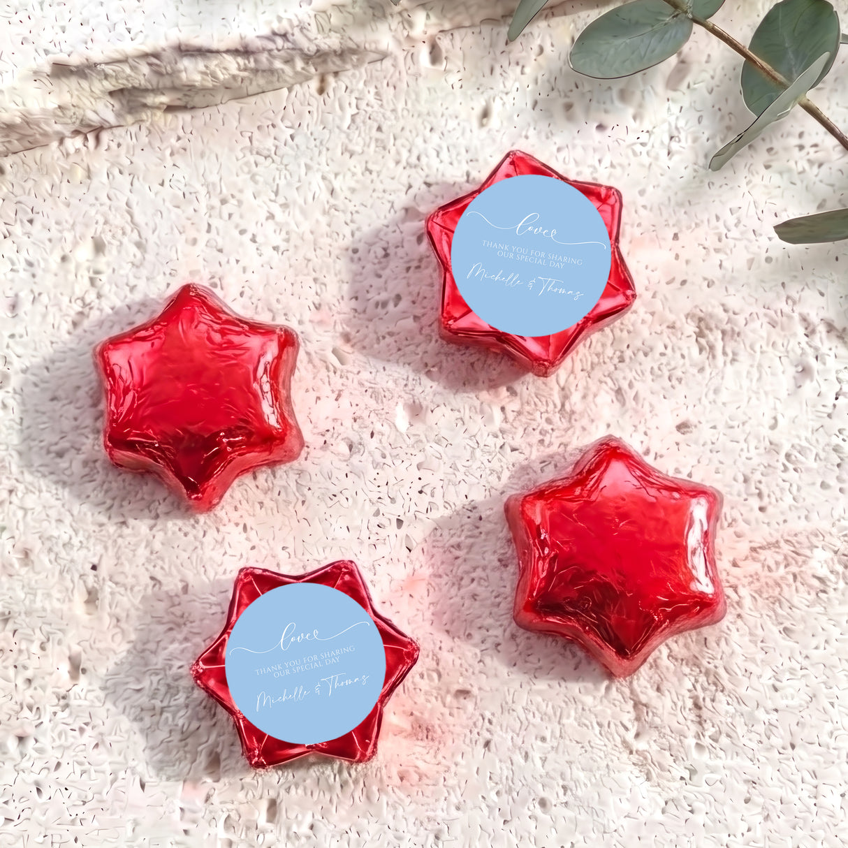 Red foil-wrapped chocolate stars with round personalized label discs
