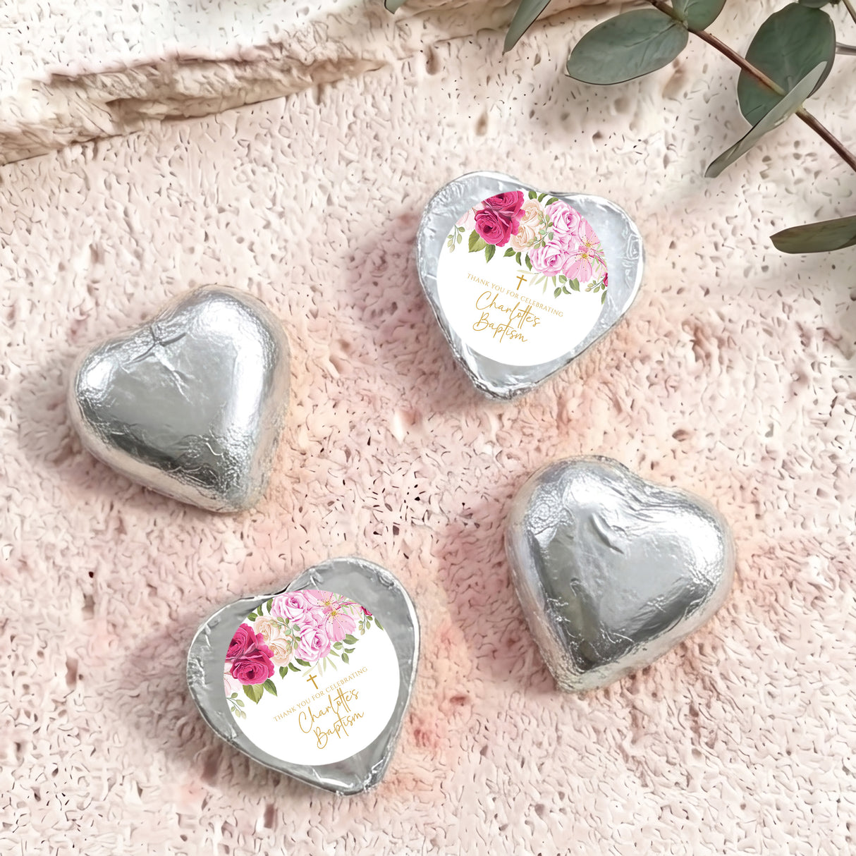 Heart-shaped foil-covered chocolate hearts in silver, with floral center labels