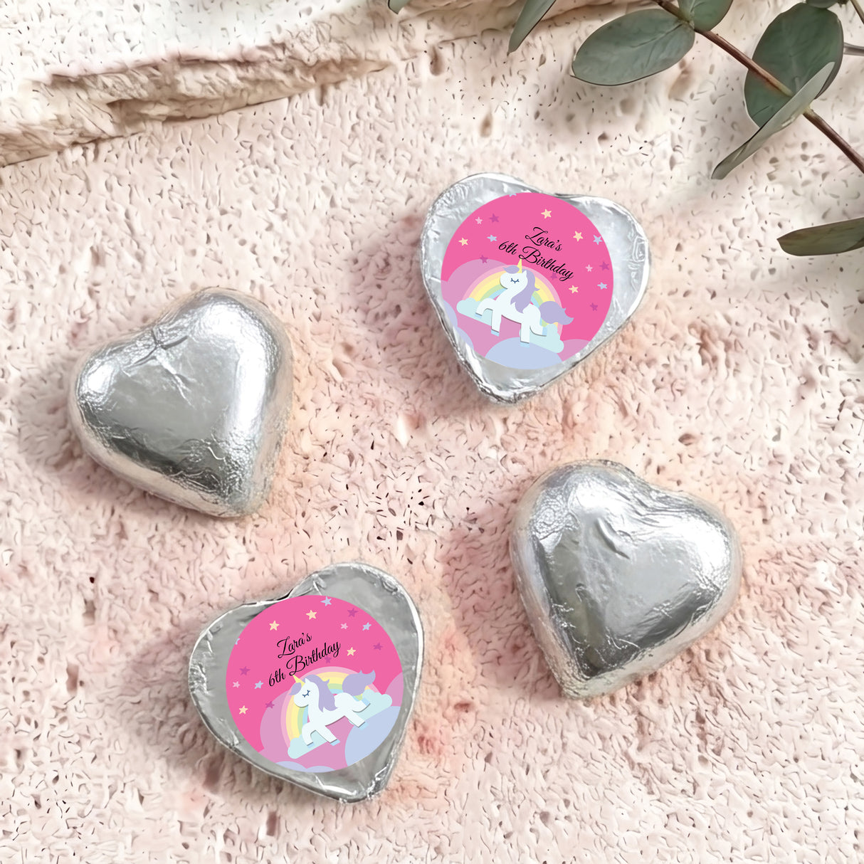 Silver foil chocolate hearts with unicorn โZaraโs 6th Birthdayโ label.