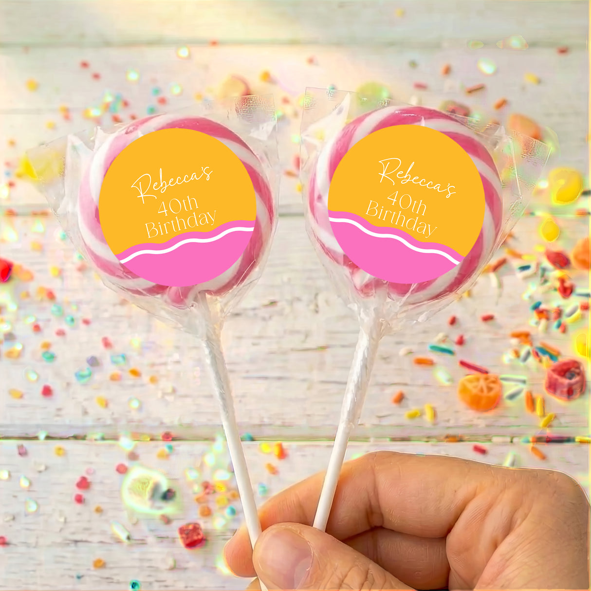 Personalised 40th birthday lollipops with pink-and-orange round labels on clear sticks