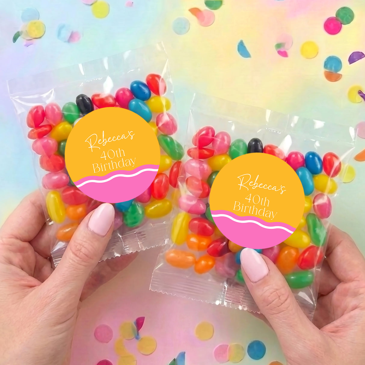 Two personalised jelly bean bags with pink labels and multicolored wavy candies