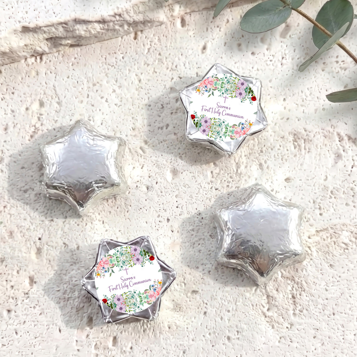 Silver star-shaped foil-covered chocolate favors with floral First Communion label