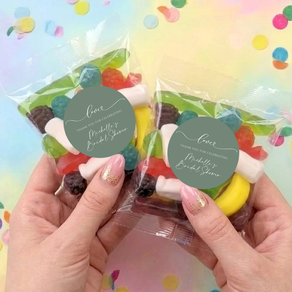 Two clear lolly bags of assorted sweets with green thank-you labels, held by hands.