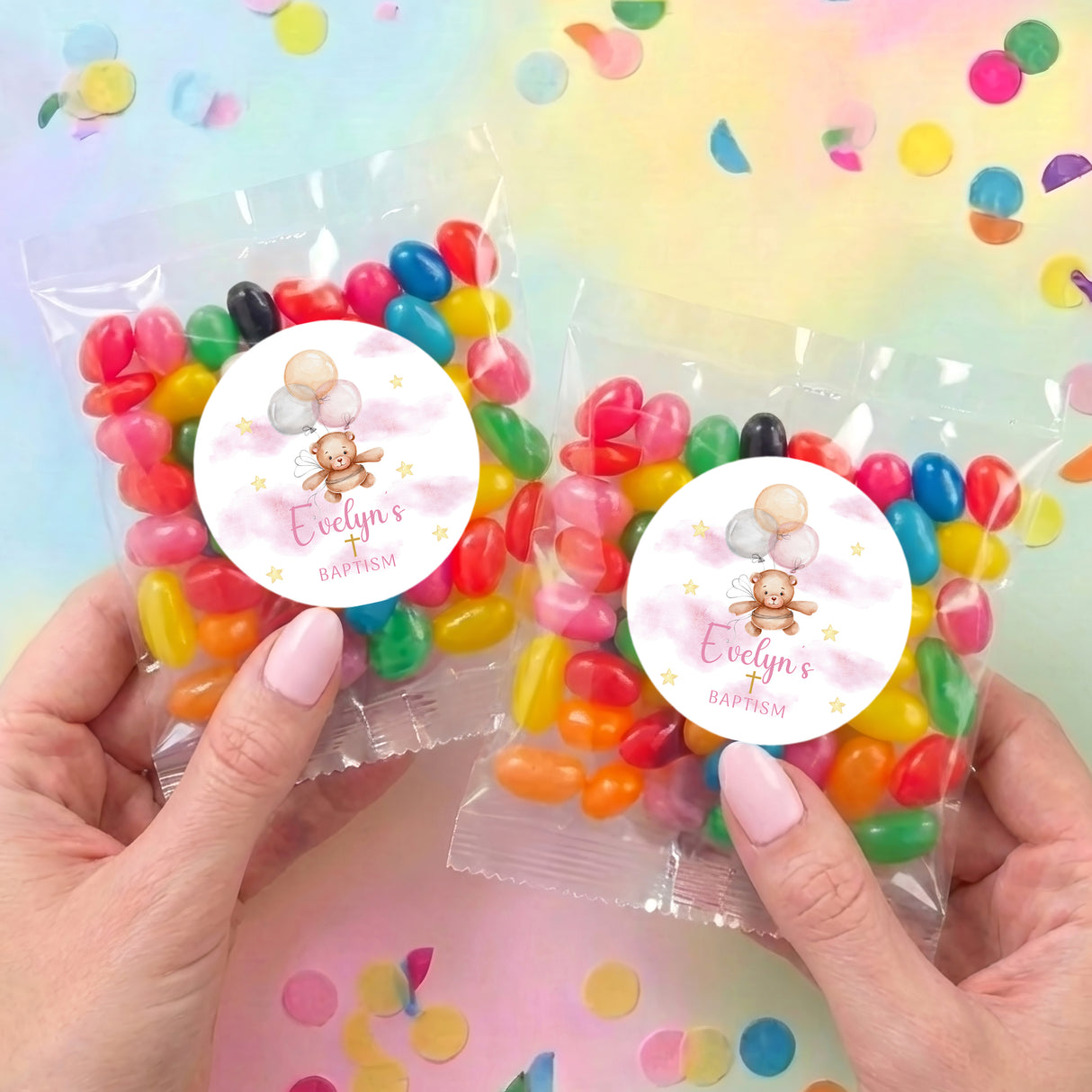 Two personalised baptism jelly bean bags held in hands, teddy balloon stickers, bright candies
