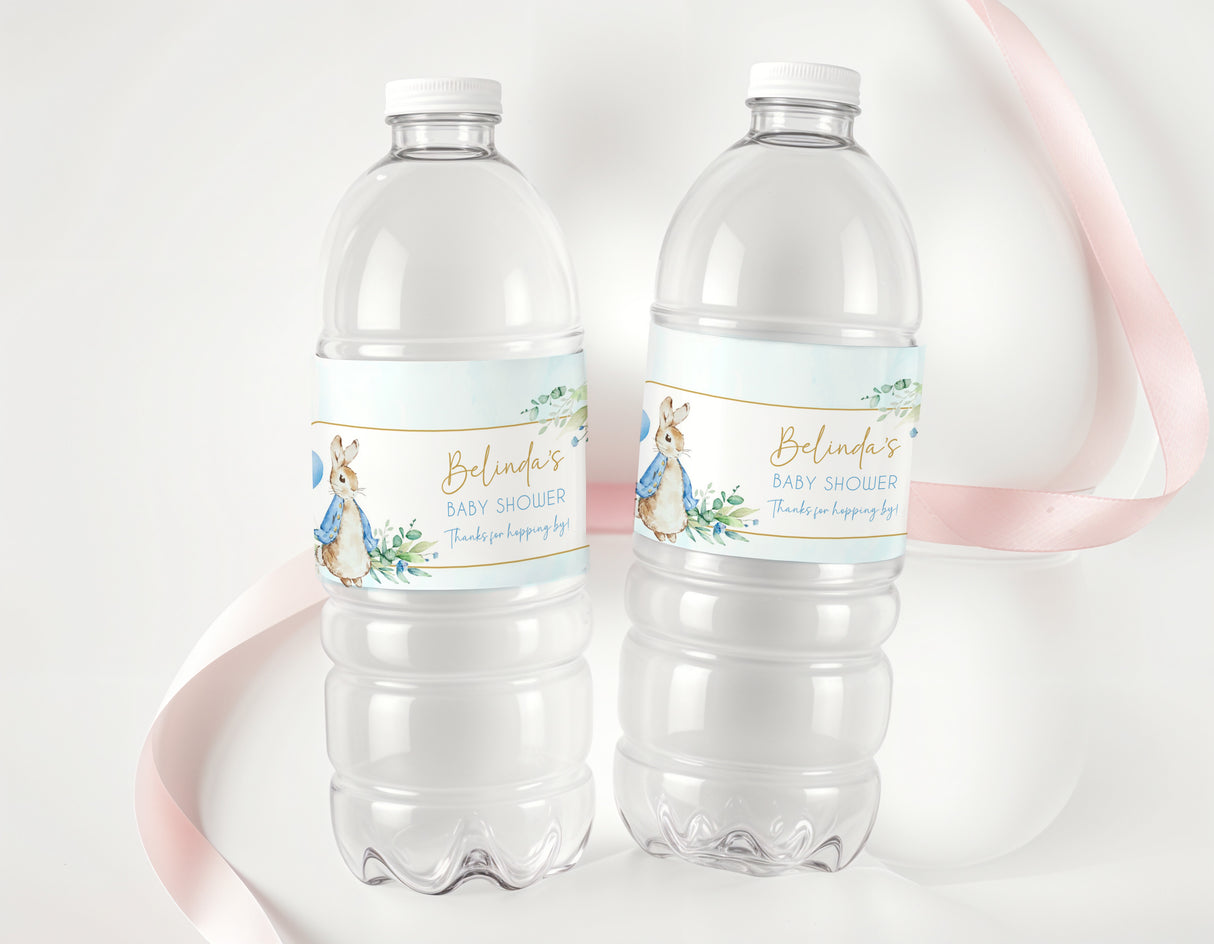 Two clear water bottles with baby shower labels, blue Peter Rabbit rabbits and flowers