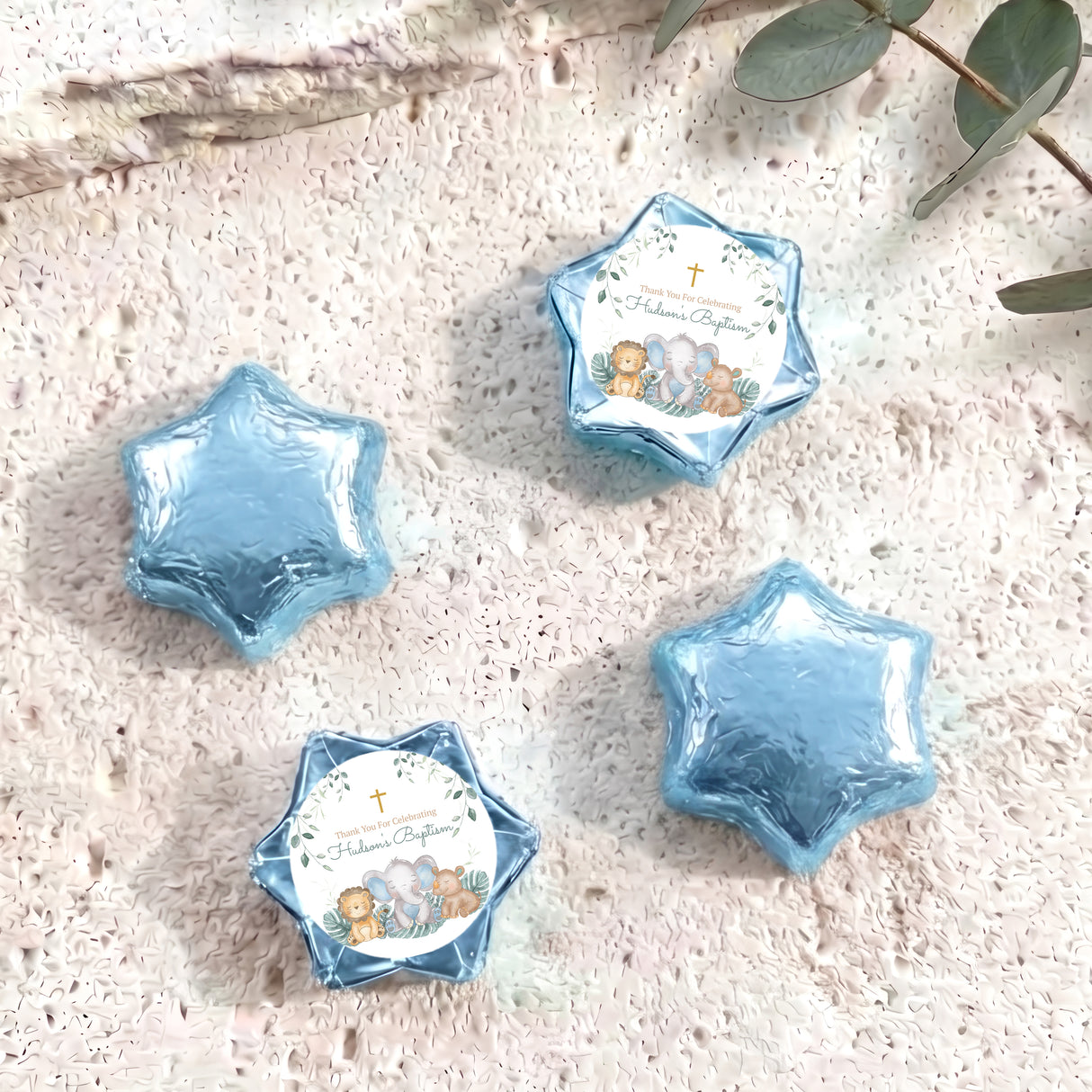 Foil-covered chocolate stars in light blue with a printed animal baptism topper