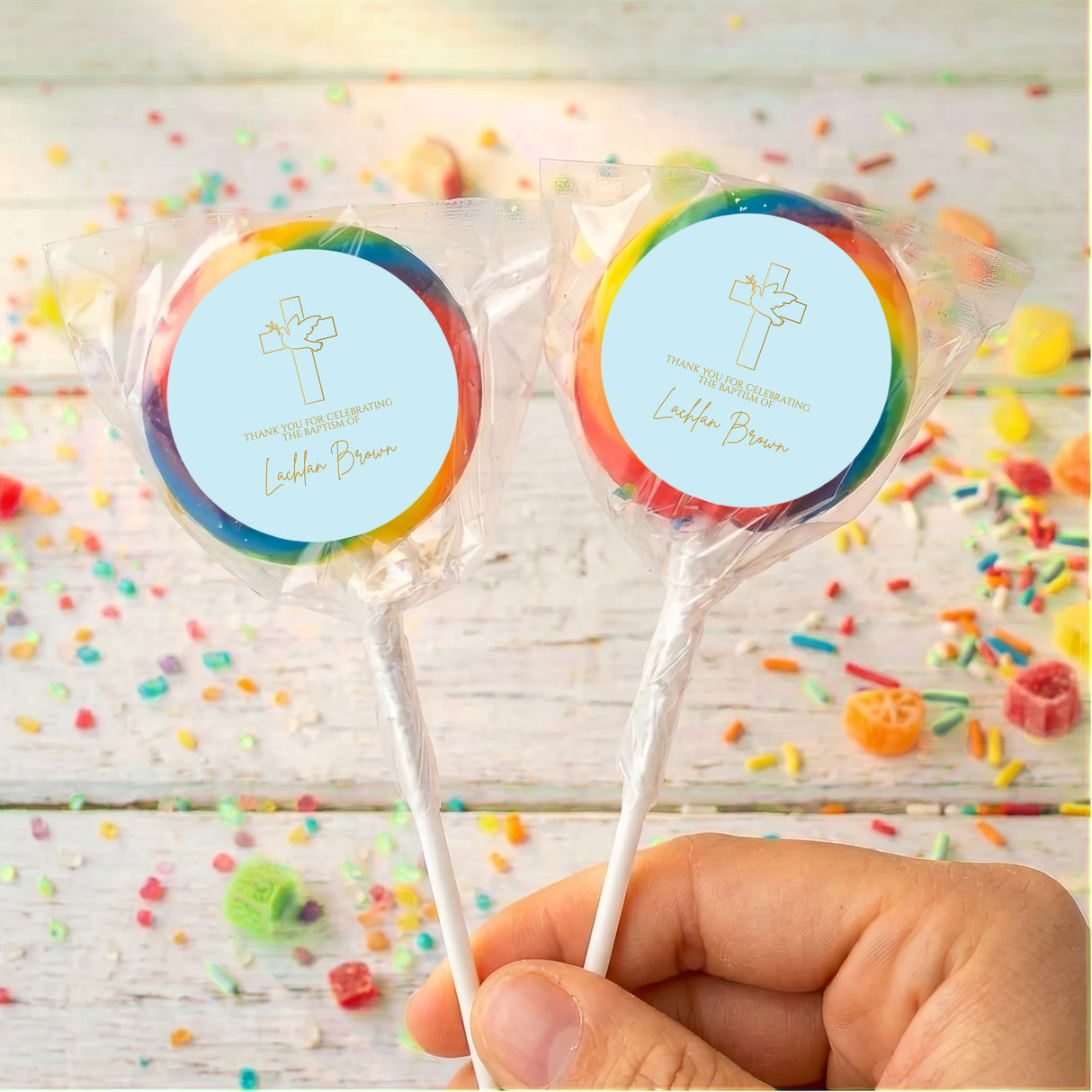 Personalised Christening lollipops with rainbow-edged blue cross labels on clear sticks
