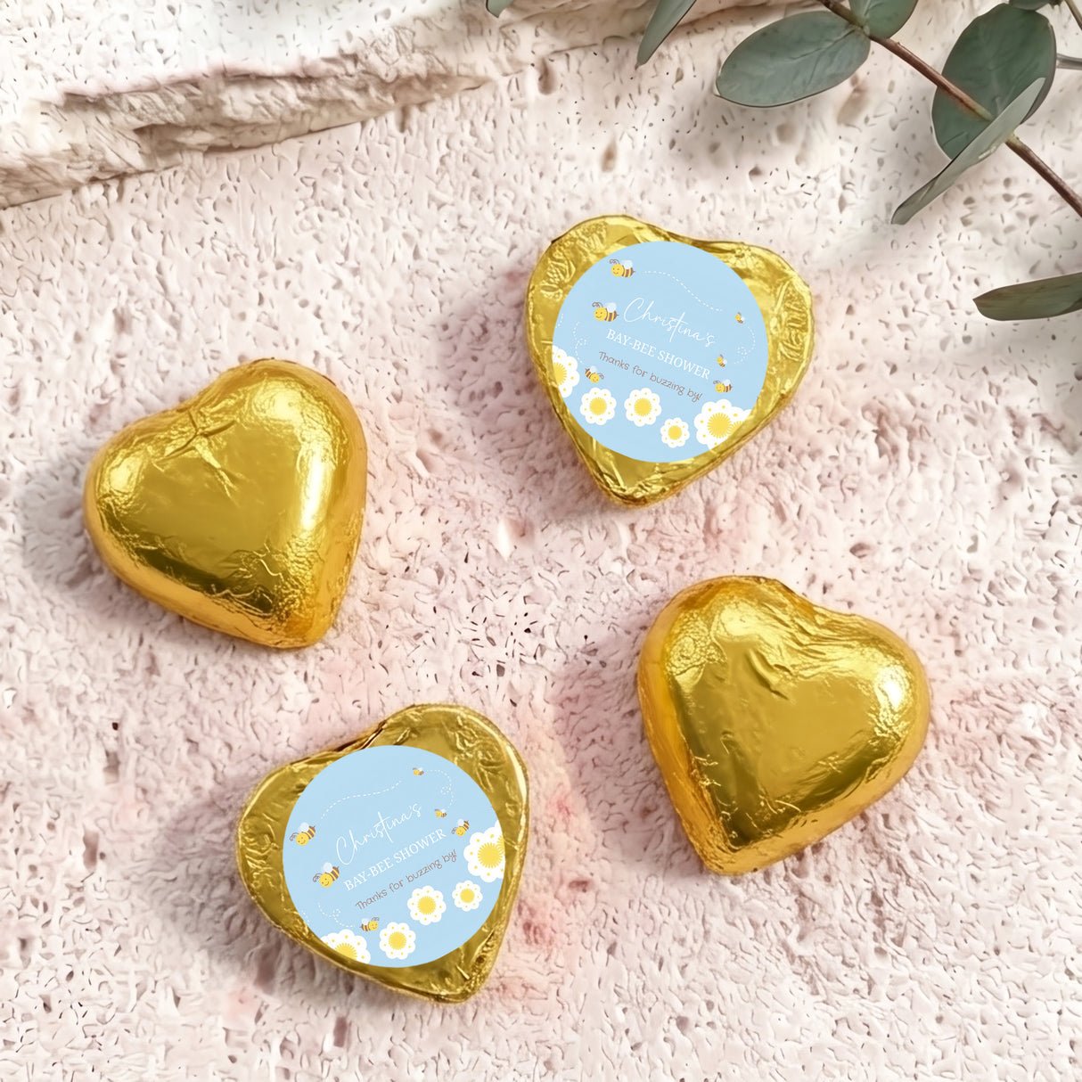 Gold foil-covered chocolate hearts with “Baby Bee Shower” gift card labels