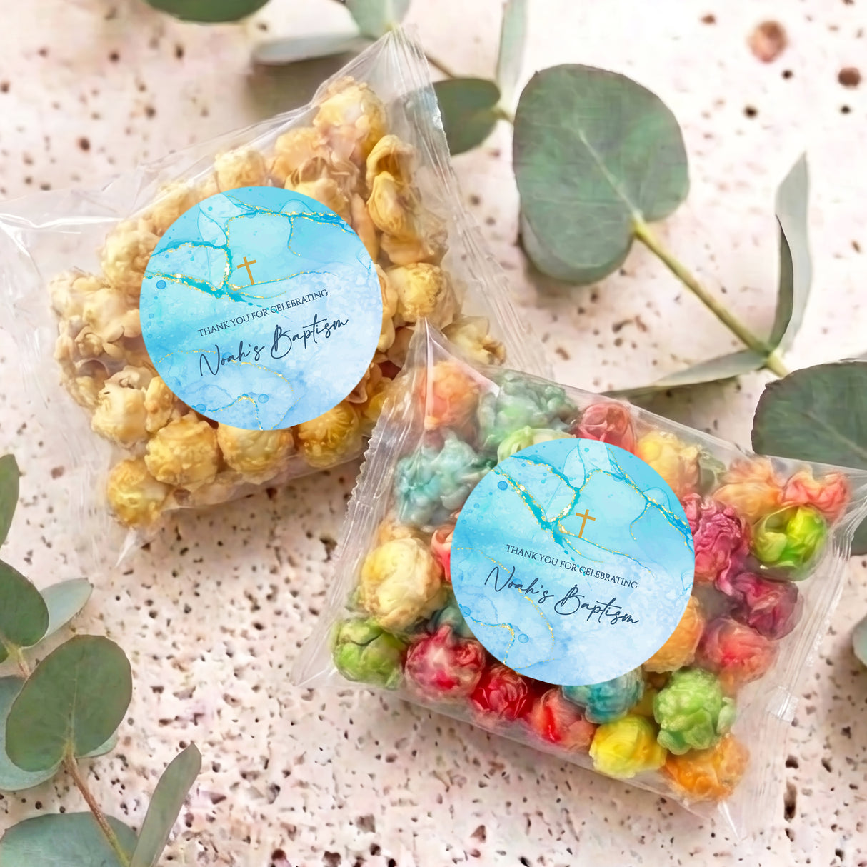 Two personalised popcorn bags with blue cross seals and colorful popcorn inside