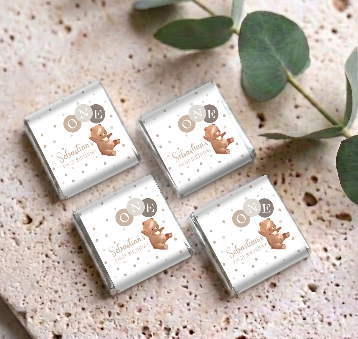 Set of personalised mini chocolates with white wrappers, bear illustrations, and 'ONE' badges