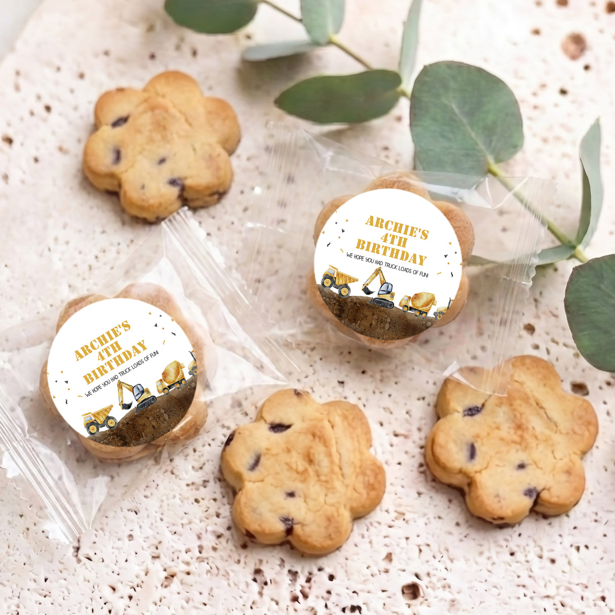 Assorted bite-size choc chip cookies with printed birthday tractor labels in clear wrappers.