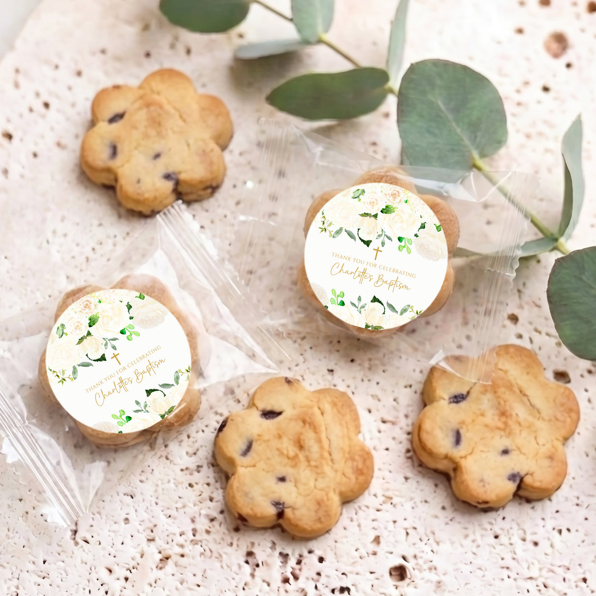 Set of personalised bite-size chocolate chip cookies with white round labels and green leaves