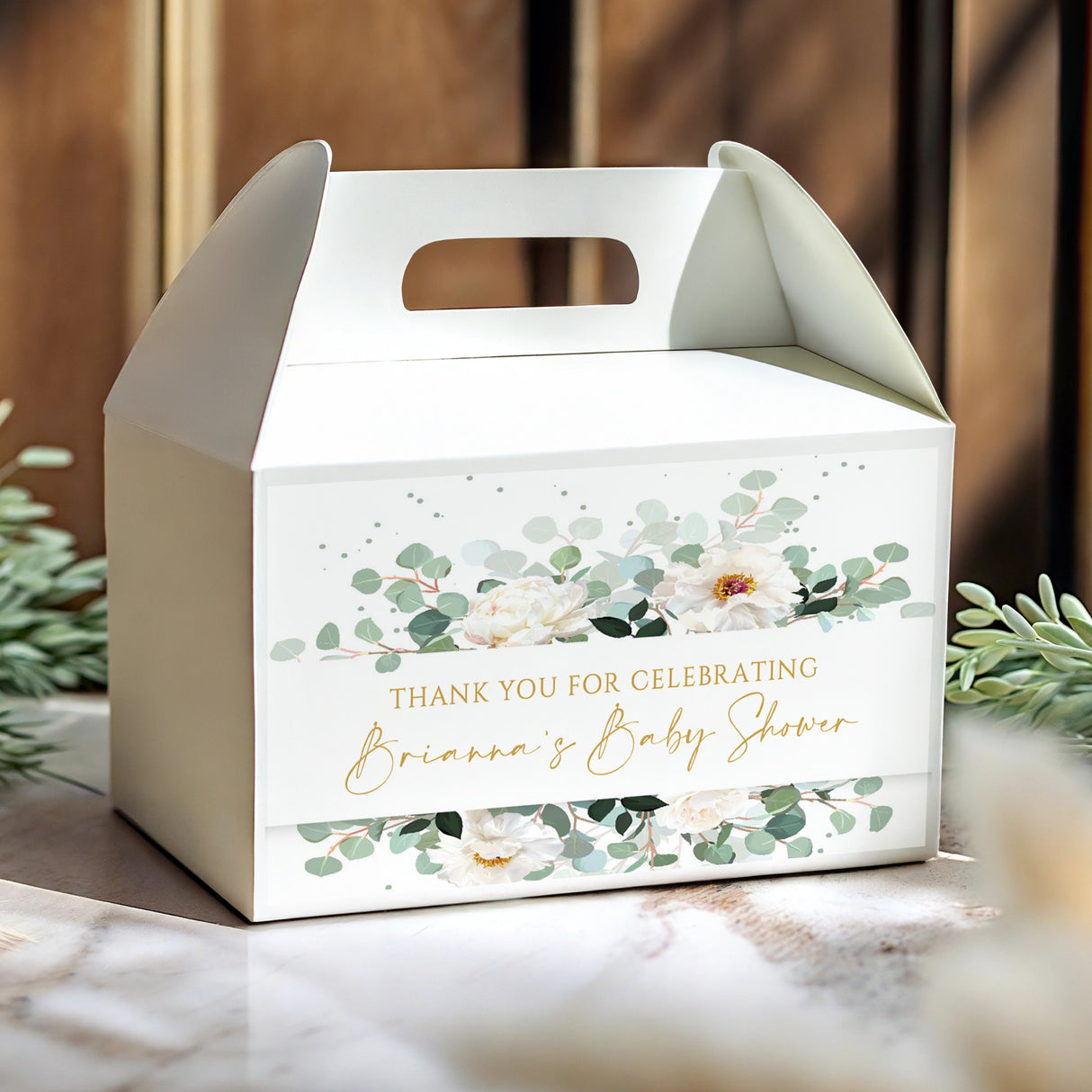 White gable favour box with eucalyptus leaves, peony flowers, and 'Brianna's Baby Shower' text