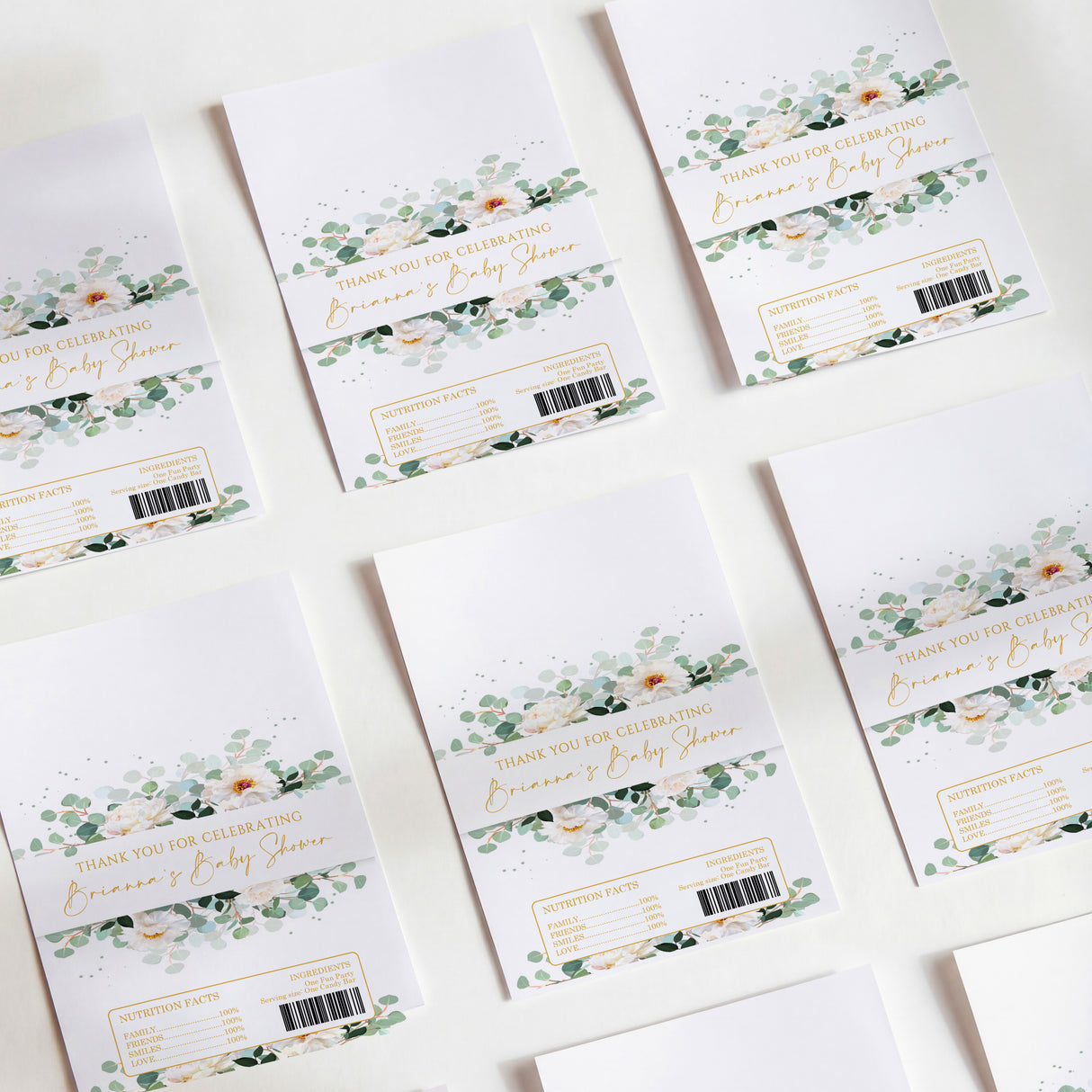 Baby shower chocolate wrappers with white base, green and floral greenery design, barcodes