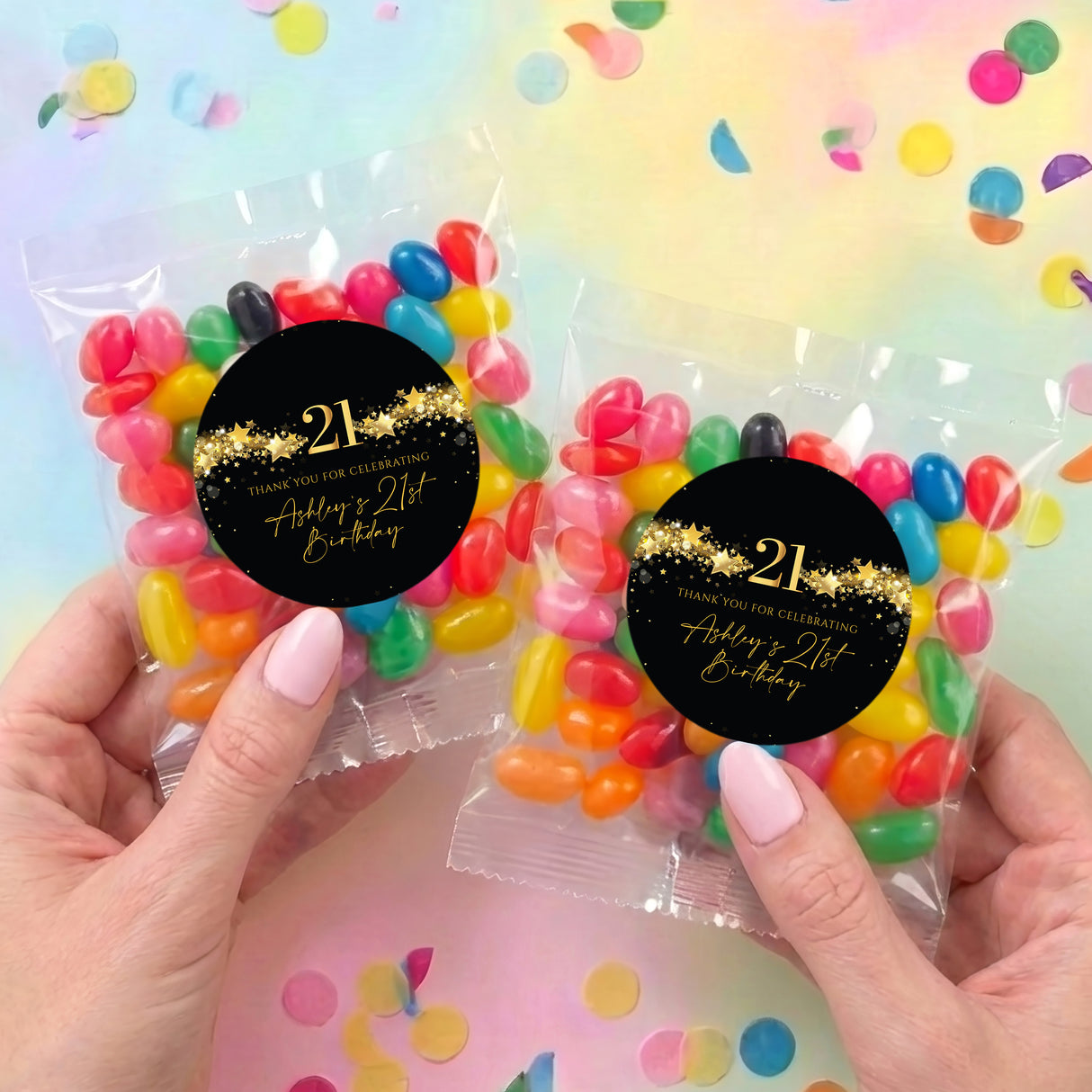 Two personalized jelly bean bags in hands, black 21st birthday labels with candies