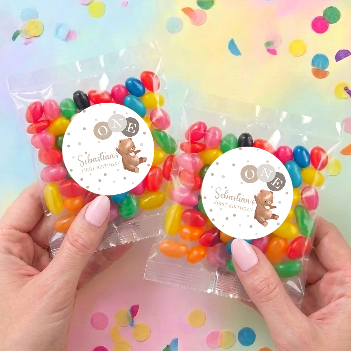 Two jelly bean gift bags with clear wrap, round bear labels, filled with colorful sweets