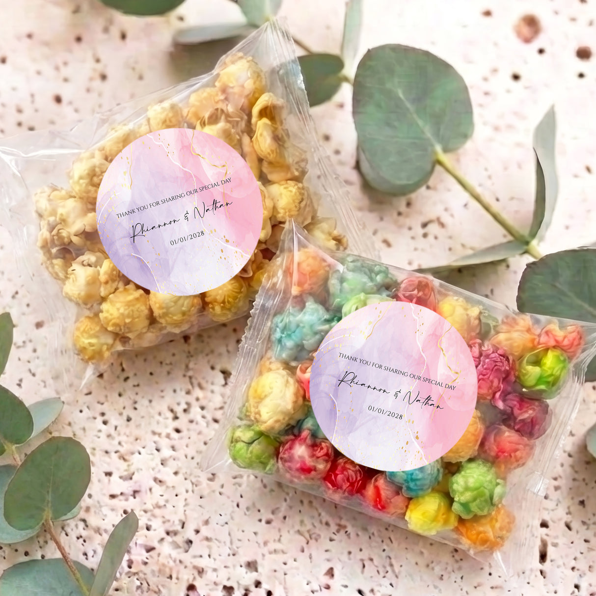 Two popcorn bags with pink-purple round stickers; clear bags of assorted popcorn