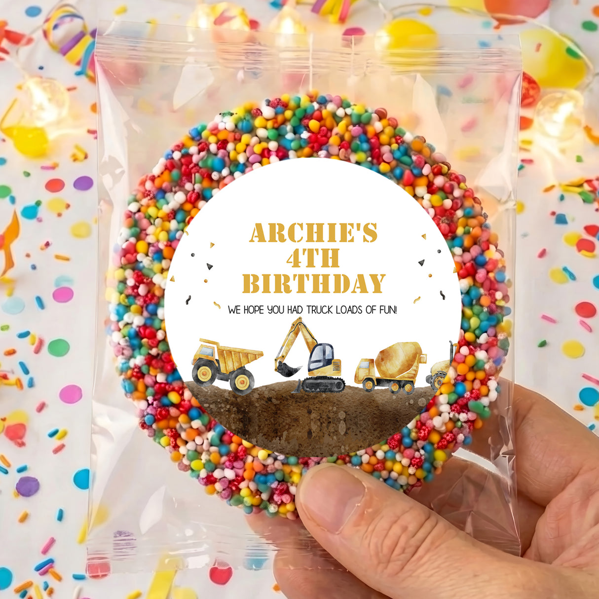 Round birthday card topper in clear bag with multicolor sprinkles and construction trucks