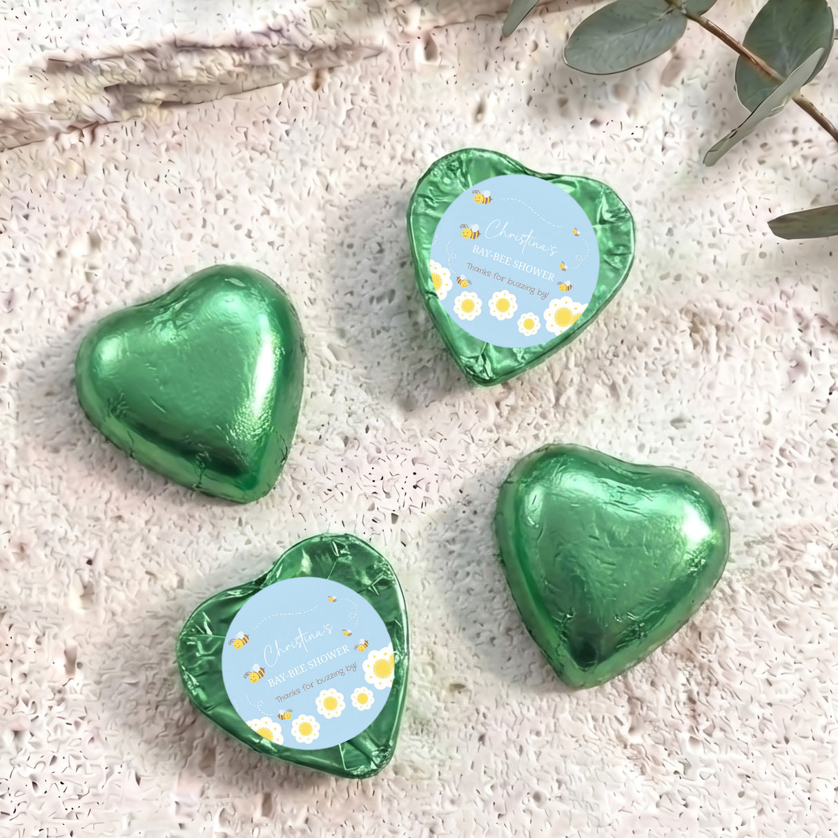 Green foil-covered chocolate hearts with “Baby Bee Shower” gift card labels