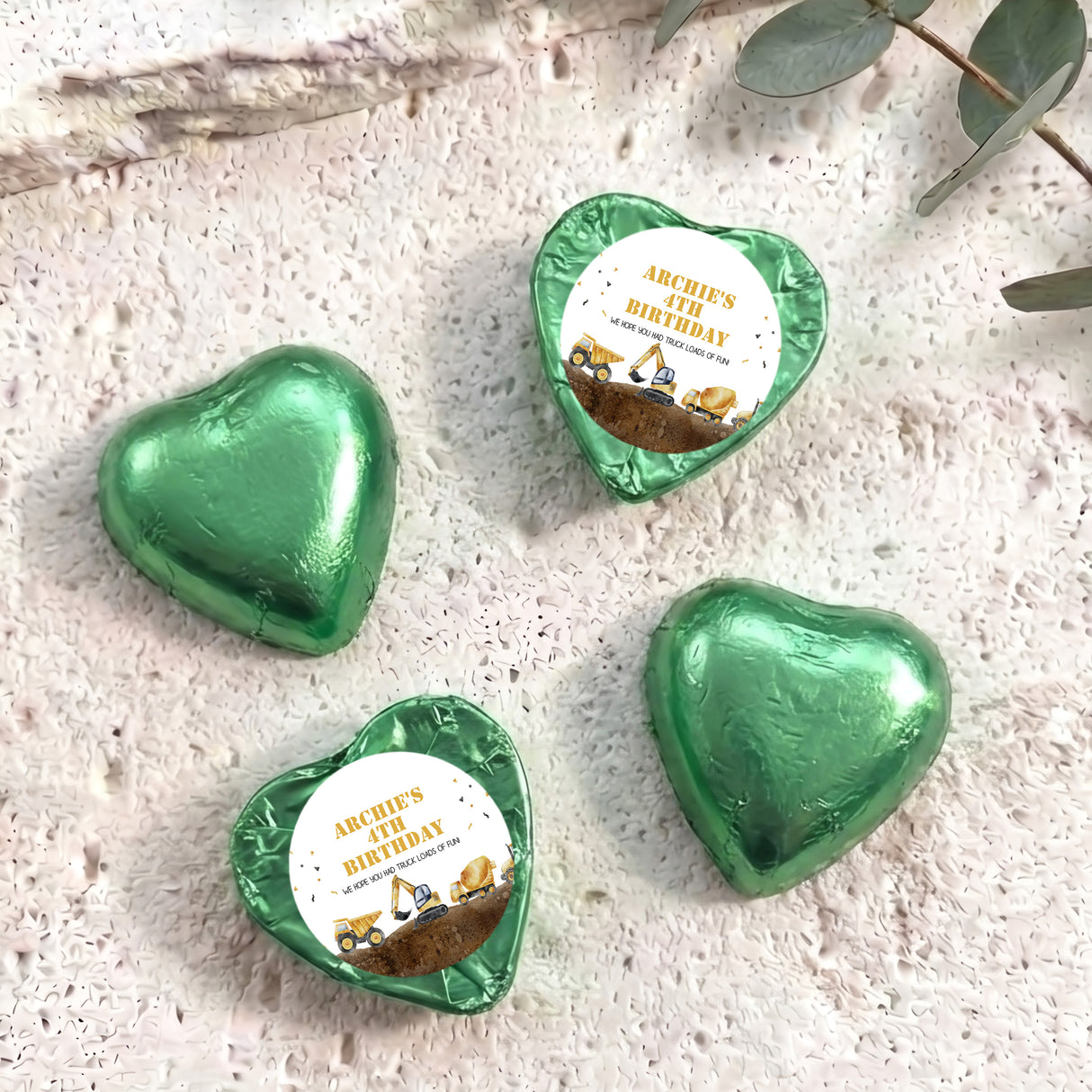 Foil-covered chocolate hearts in green foil with birthday label featuring a construction truck