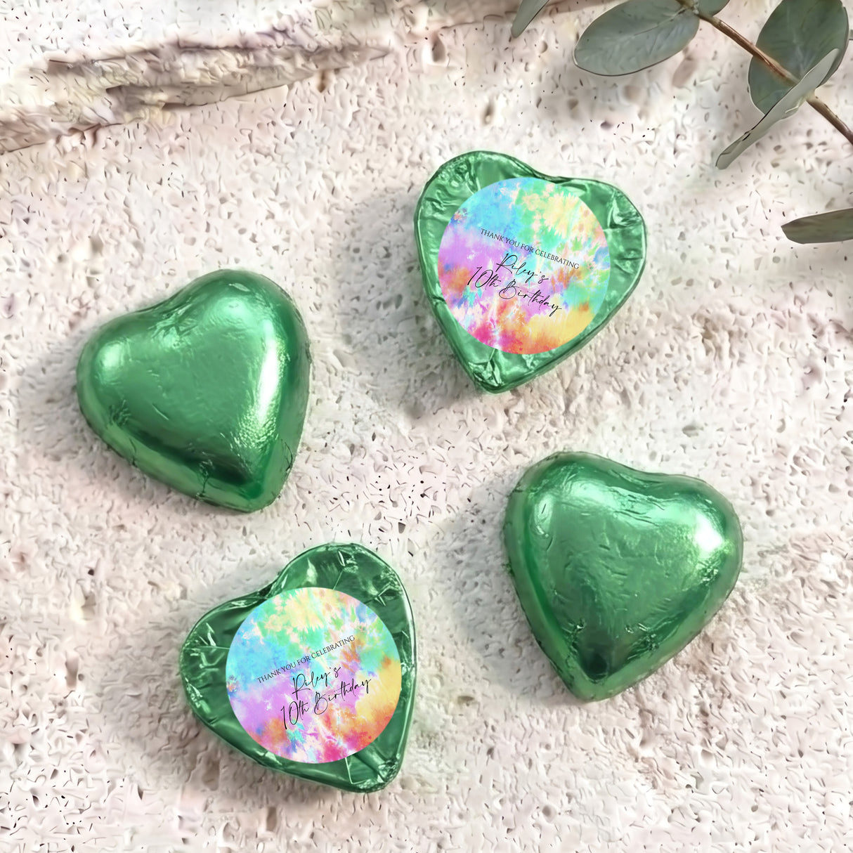 Green foil covered heart chocolates with colorful printed center