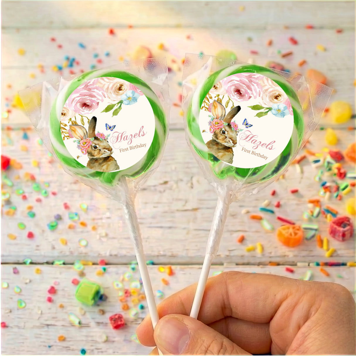 Personalised bunny floral lollipops with green-bordered round labels, held in hand