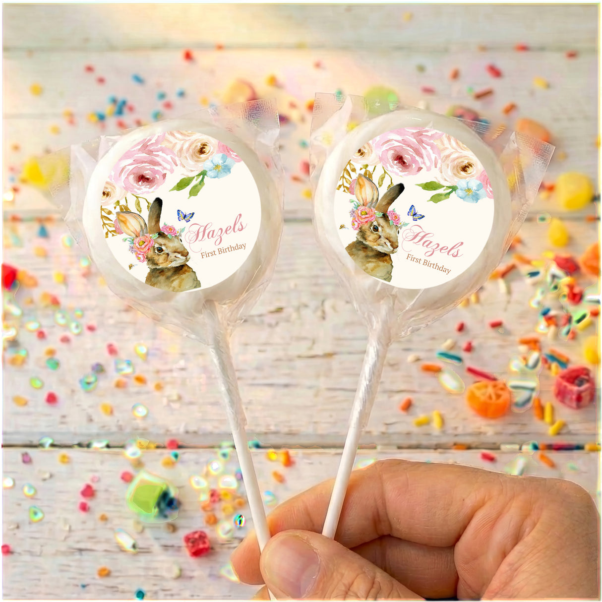 Personalised bunny floral lollipops with pastel round labels, held in hand