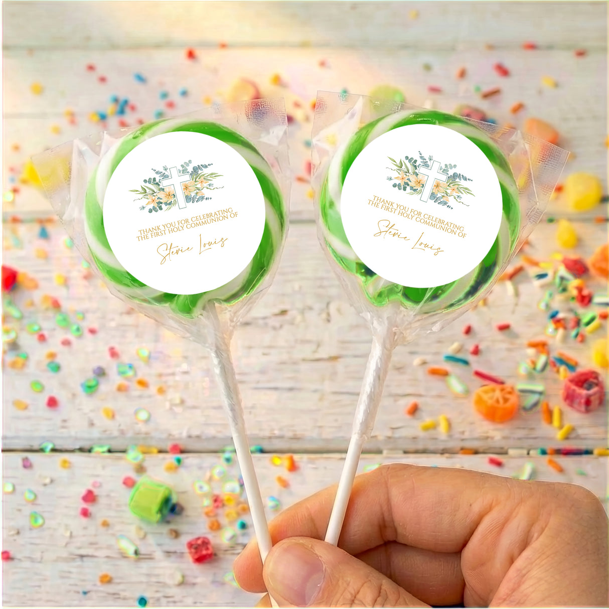 Personalised lollipops with floral cross labels, green accent, clear wrap, hand held