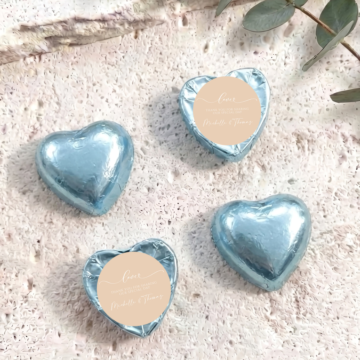 Foil-covered chocolate hearts, light blue, with round personalised message label