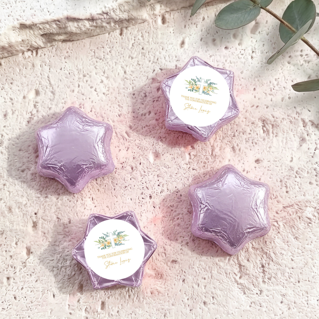 Lavender/purple foil-covered chocolate stars with personalised circular cross label on wrappers