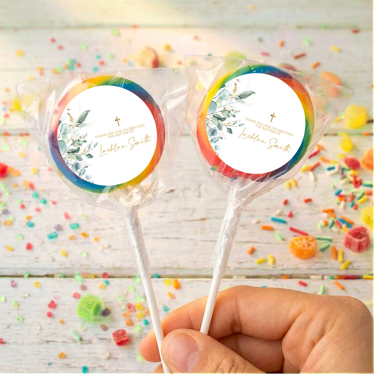 Personalised baptism lollipops: two rainbow-edged white labels, floral cross design