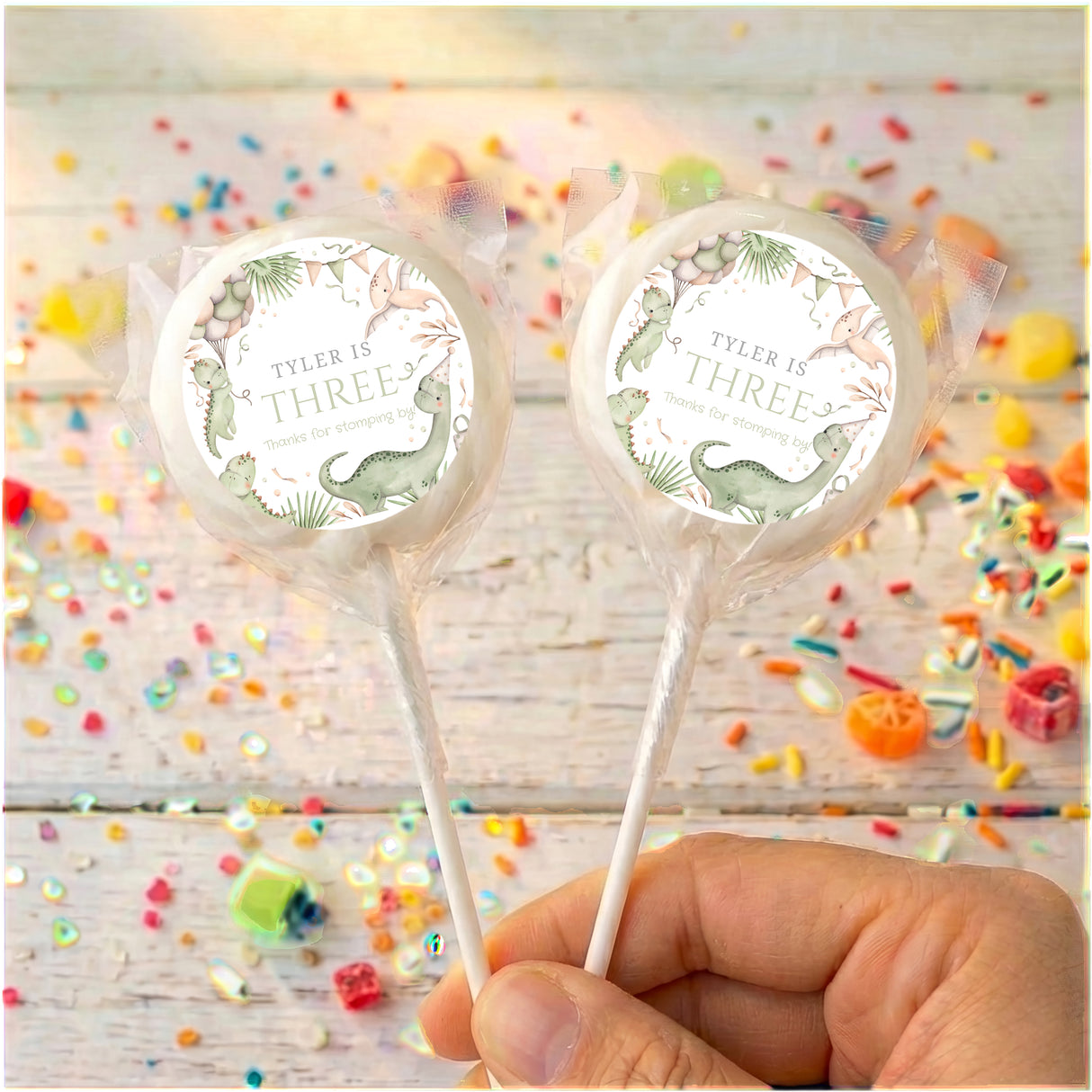 Personalised dinosaur birthday lollipops with white round labels and clear wrappers