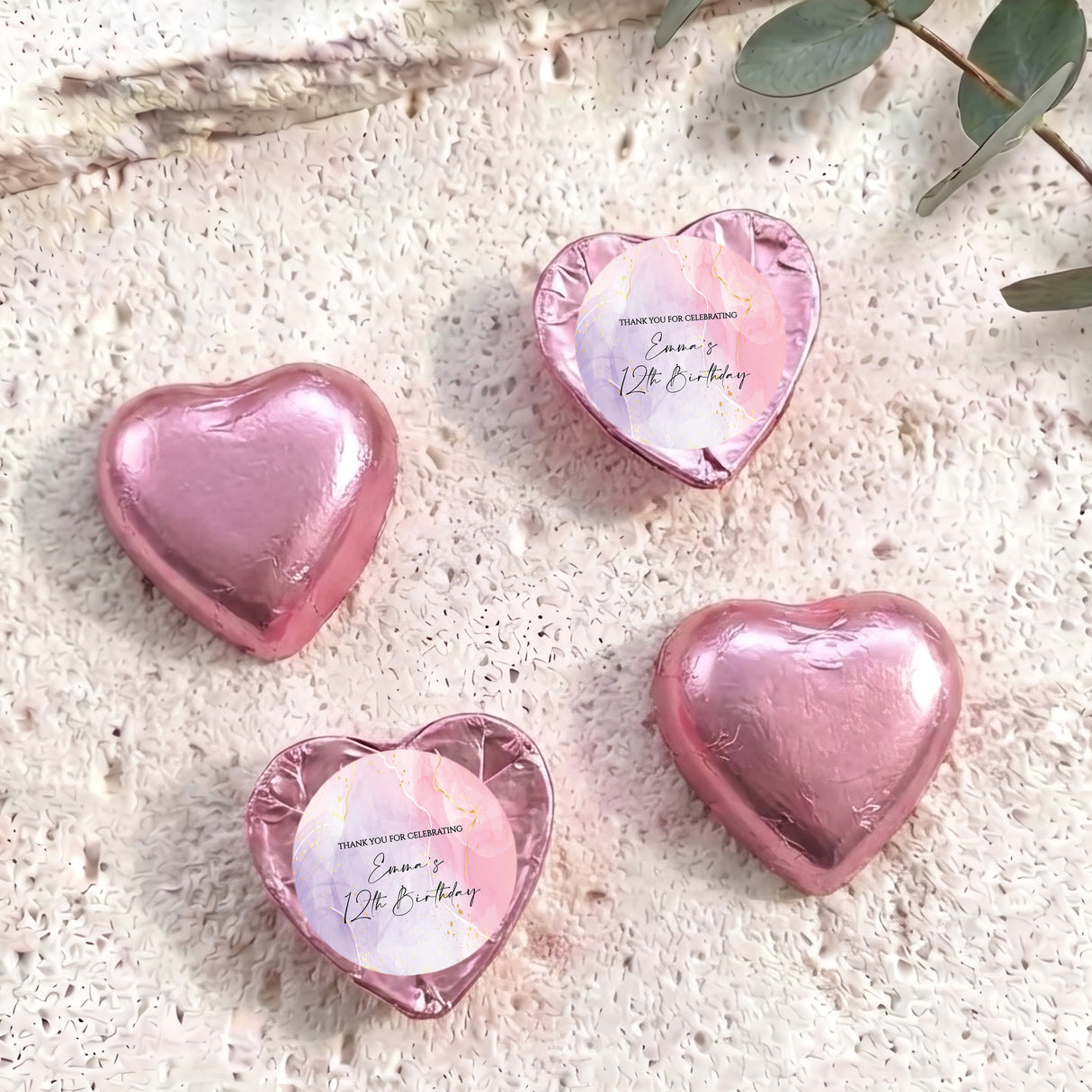 Pink foil-covered heart chocolates with round personalised labels on top