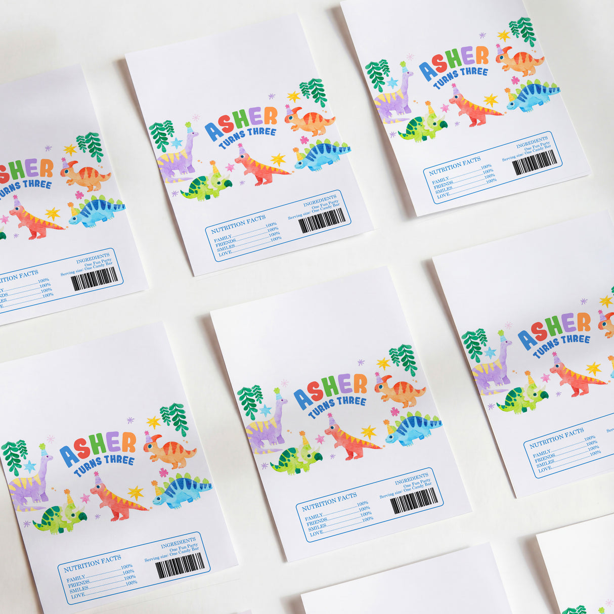 White printed chocolate birthday wrappers with colorful dinosaur design and Asher text