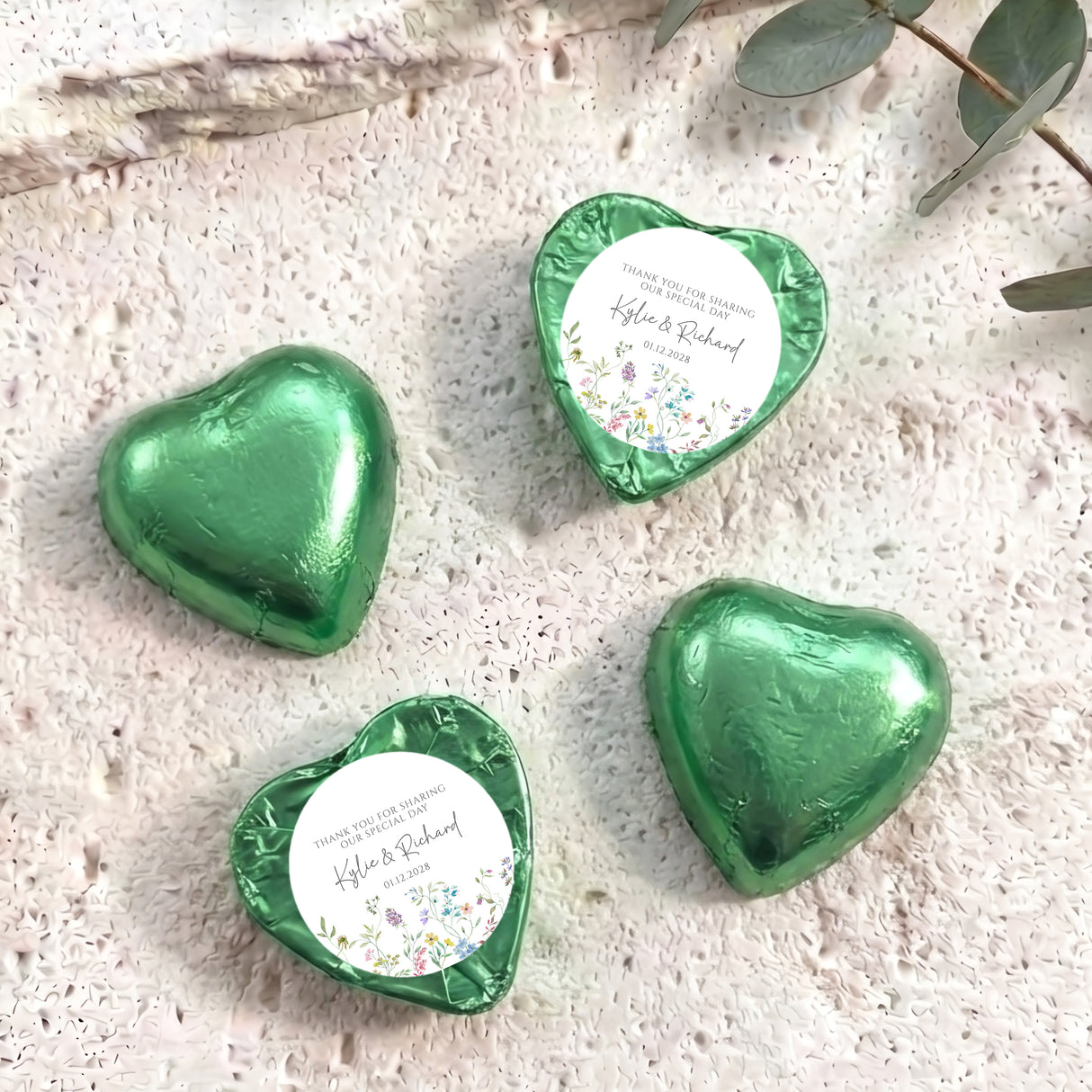 Personalised foil-covered chocolate heart favours in green foil, with printed thank-you labels
