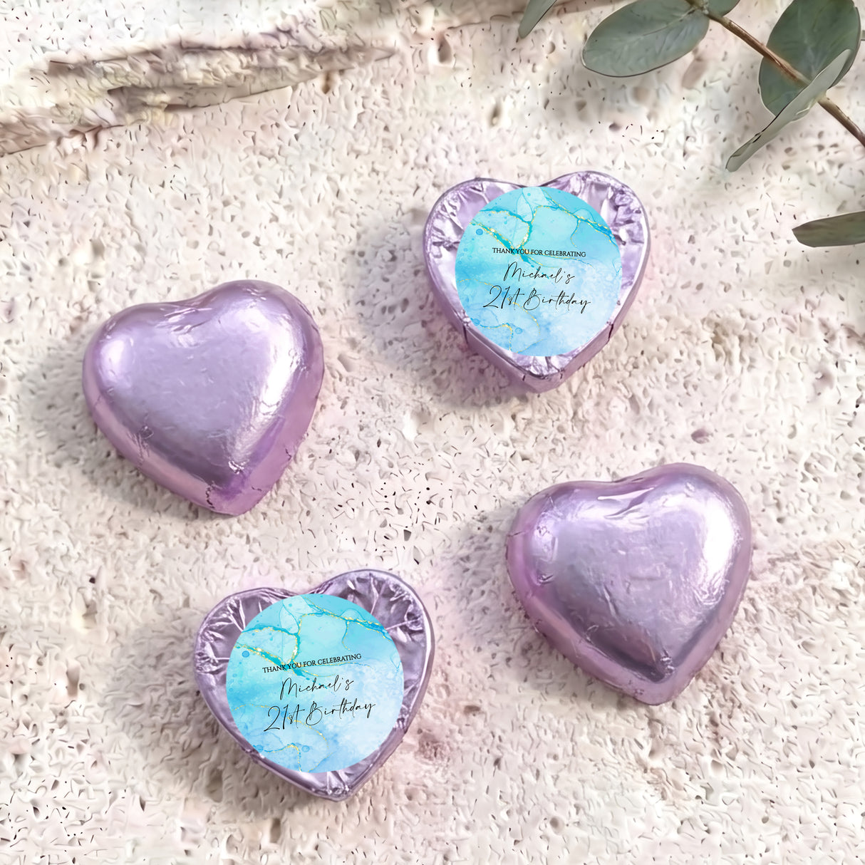 Foil-covered chocolate hearts in lavender, each with a printed birthday message.