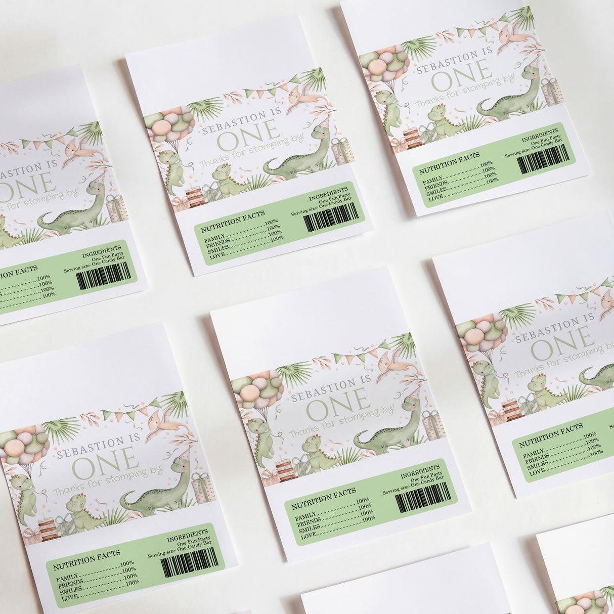 Dinosaur first birthday chocolate wrappers, green nutrition panel and βOneβ text
