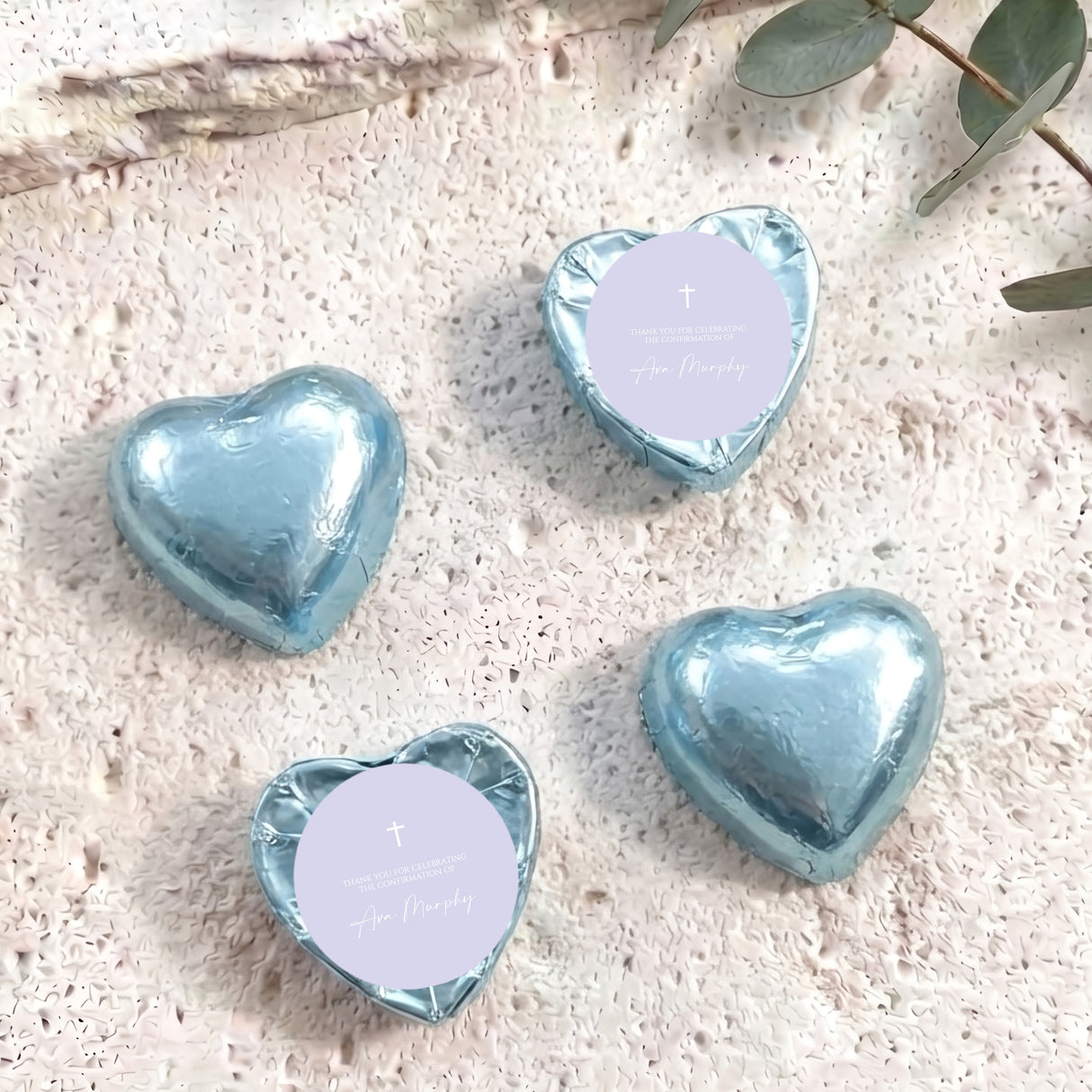 Foil-covered chocolate hearts, light blue foil with white tops and small cross