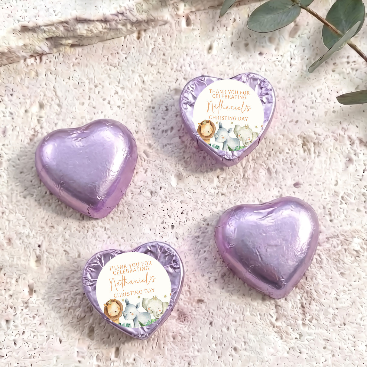 Purple foil-covered chocolate heart with round Christening label and baby animals