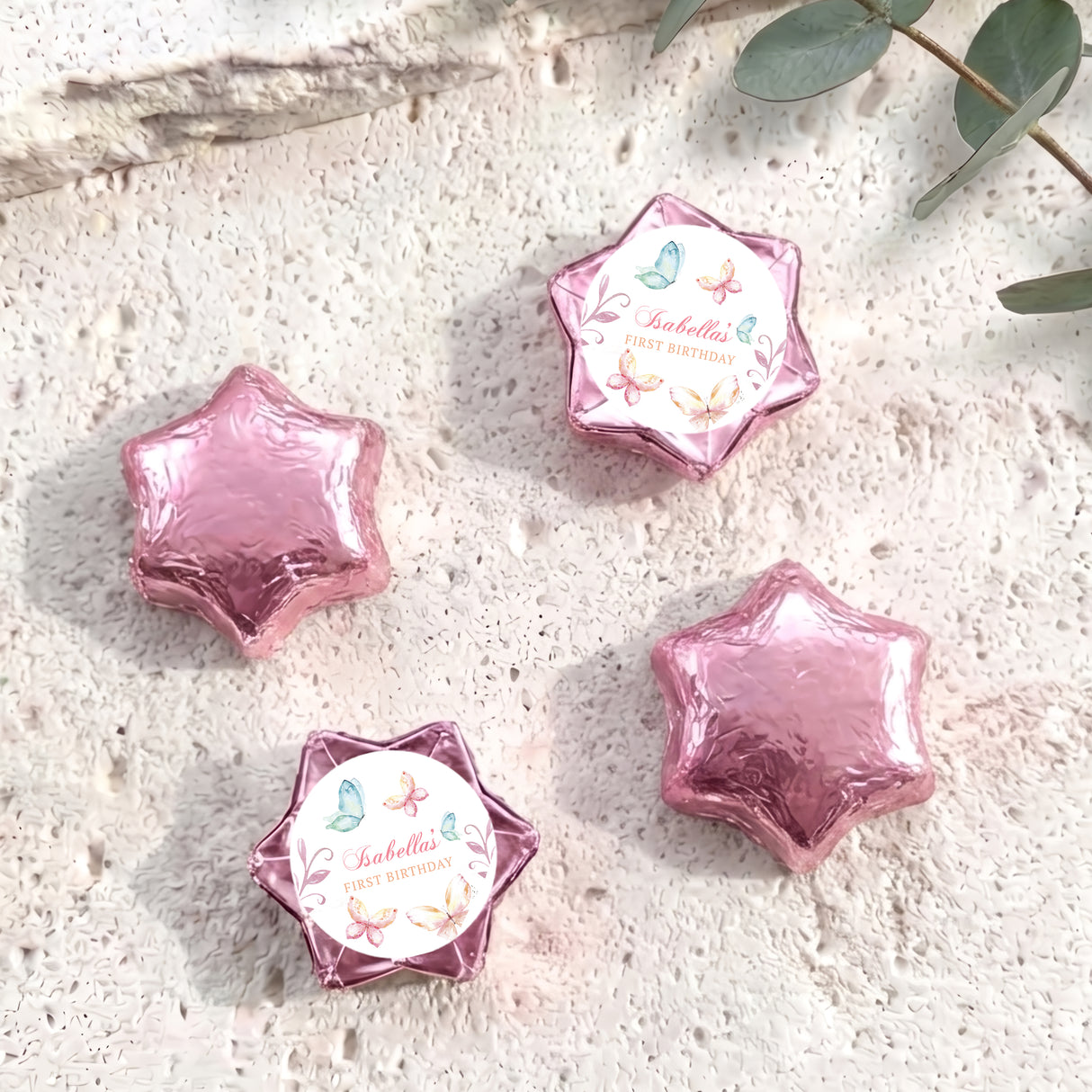Pink foil-covered chocolate stars with a round personalised label on one star