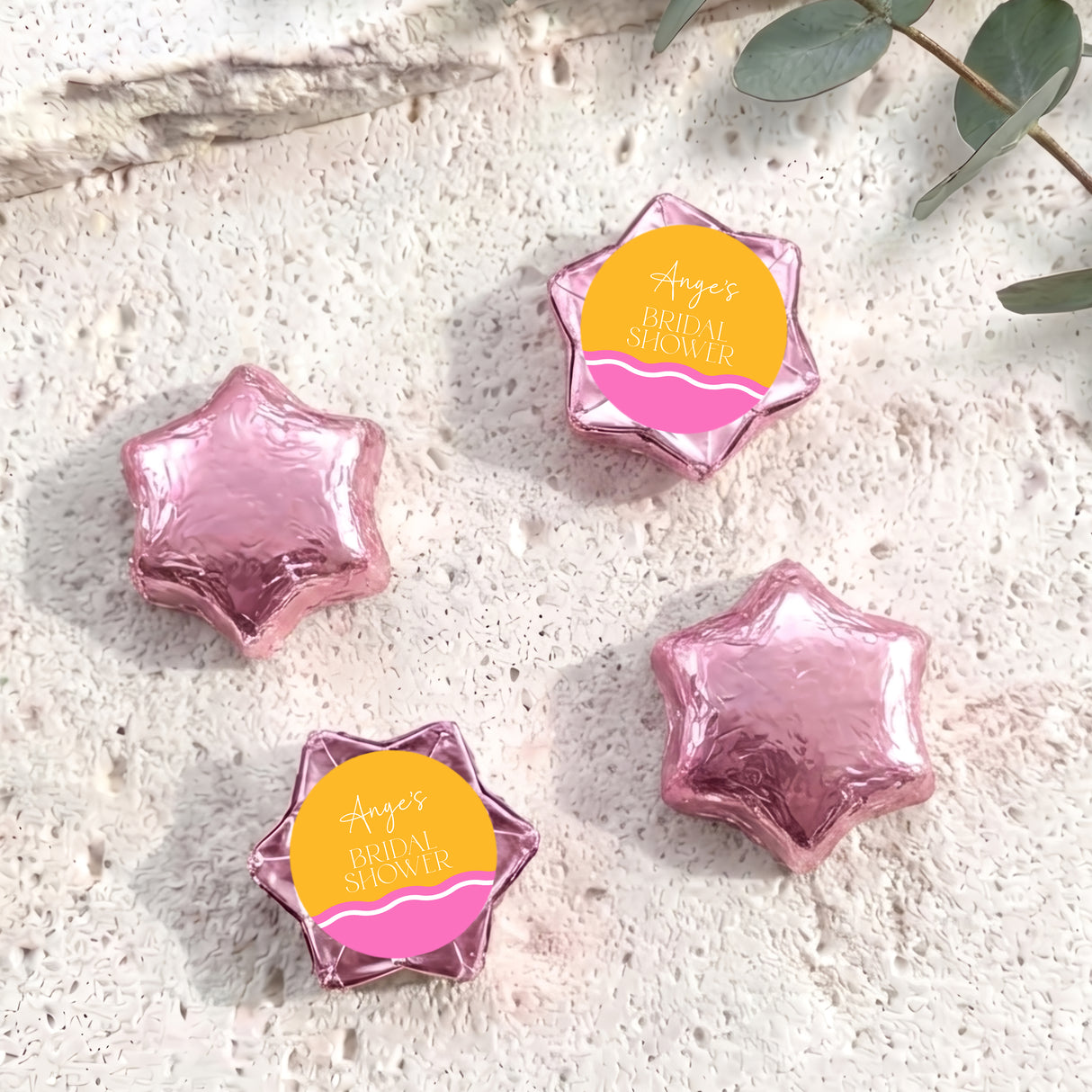 Foil-covered chocolate stars in pink, three star-shaped foil chocolates.
