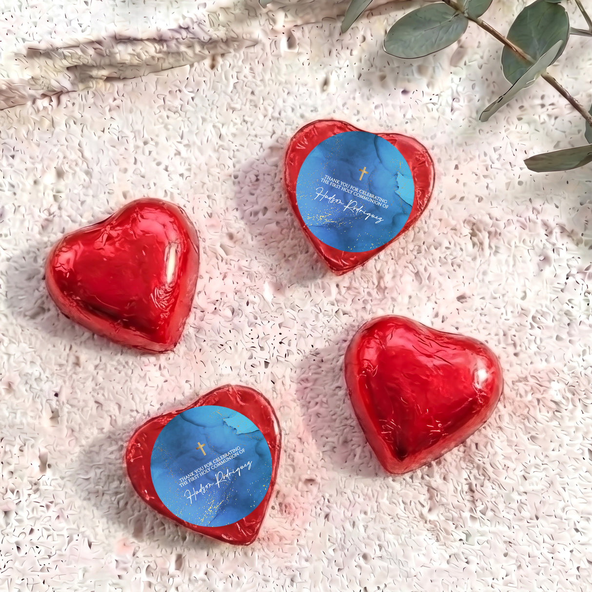 Foil-covered chocolate hearts with red wrappers and gold cross design