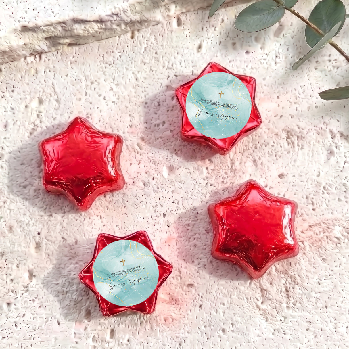 Foil-covered red chocolate stars with white cross and personalised message card