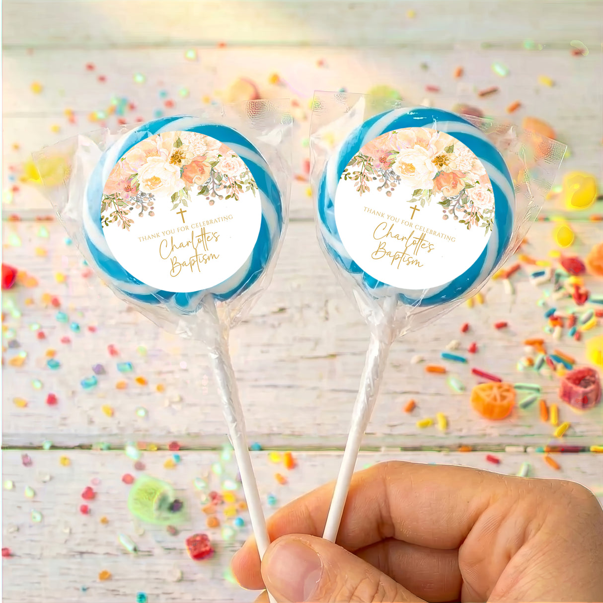 Personalised christening lollipops with blue wrapped candy and floral name labels