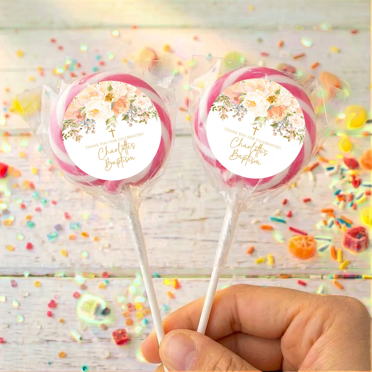 Personalised christening lollipops with pink wrapped candy and floral name labels