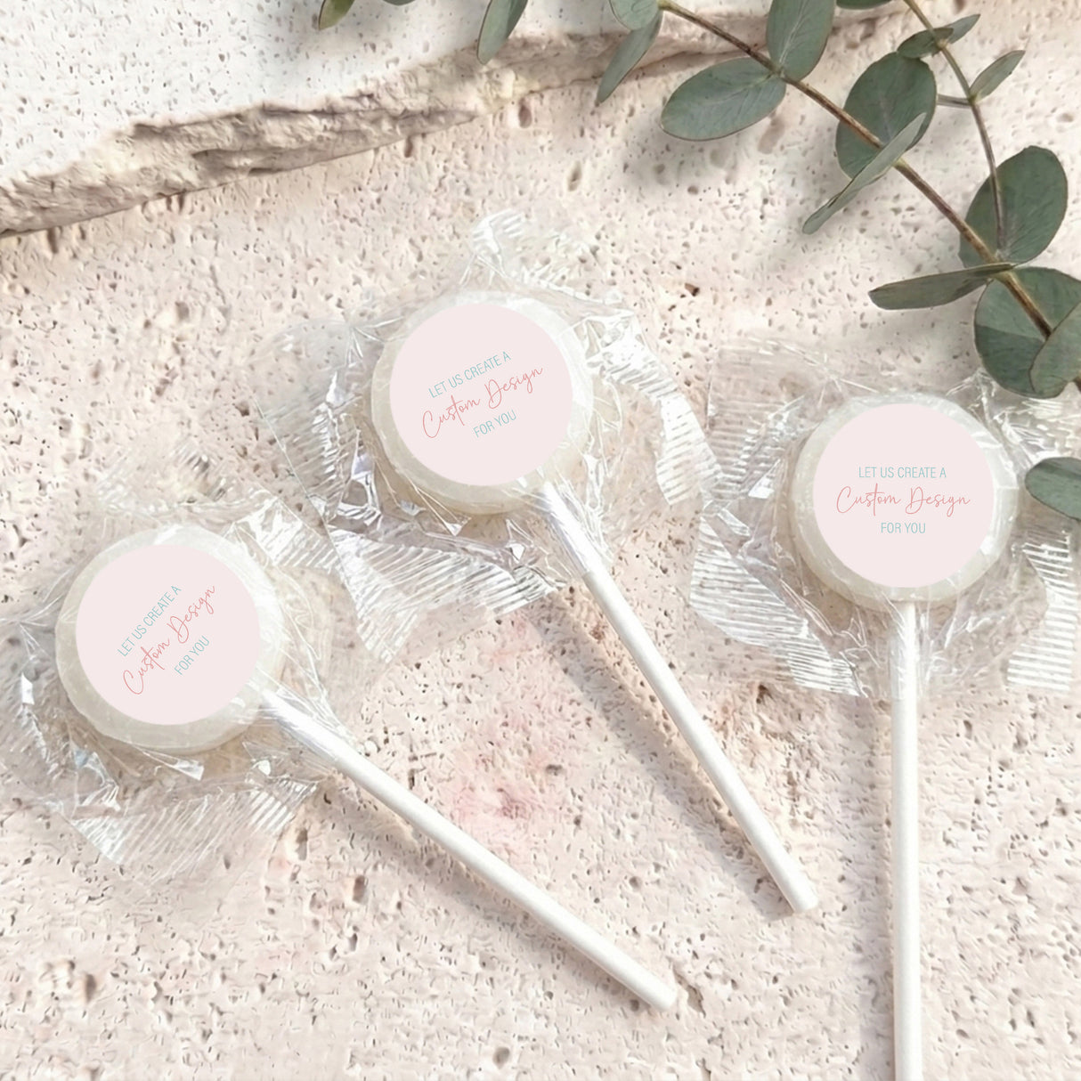 Mini lollipops with yellow lollipop tops, wrapped in clear plastic on white sticks.