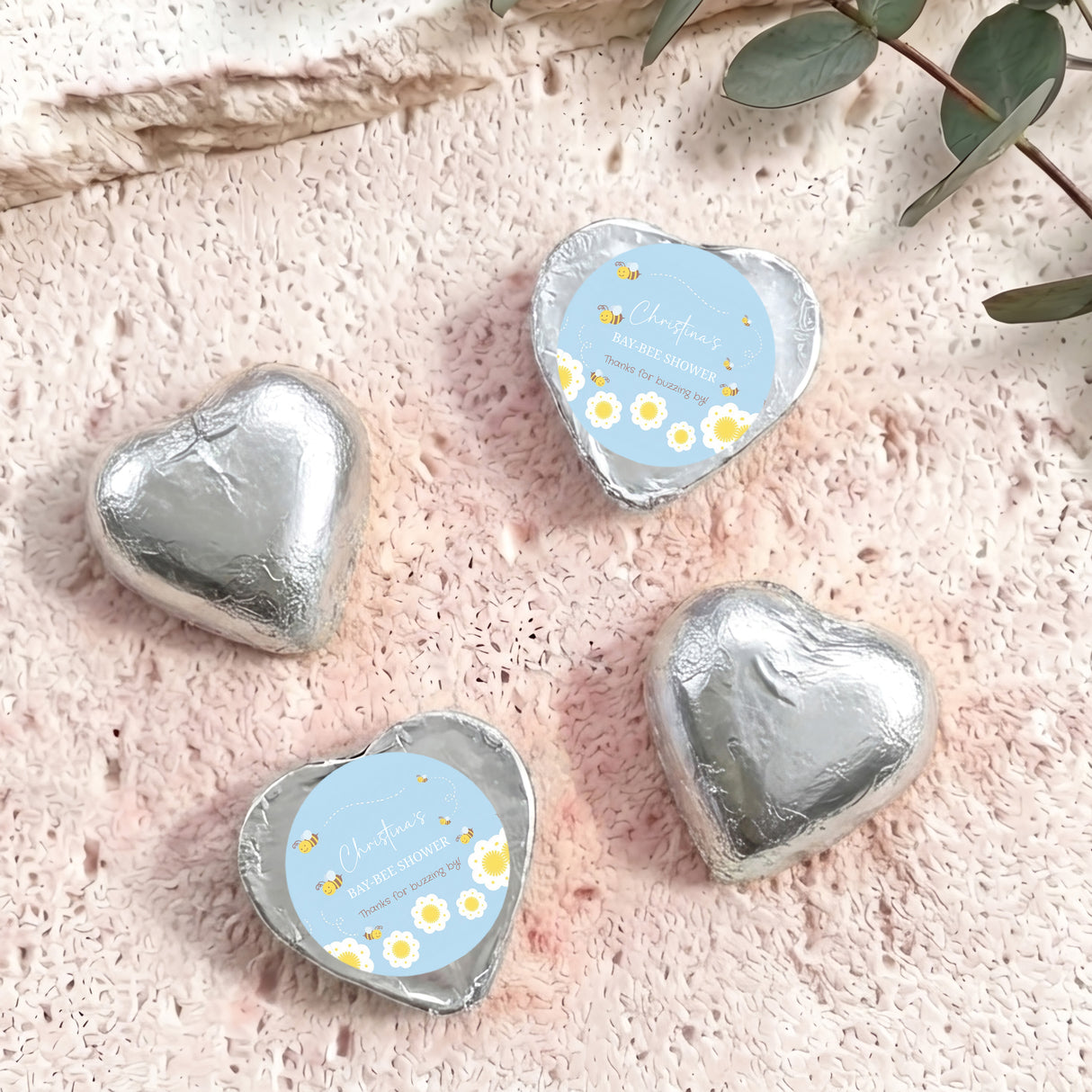 Silver foil-covered chocolate hearts with “Baby Bee Shower” gift card labels