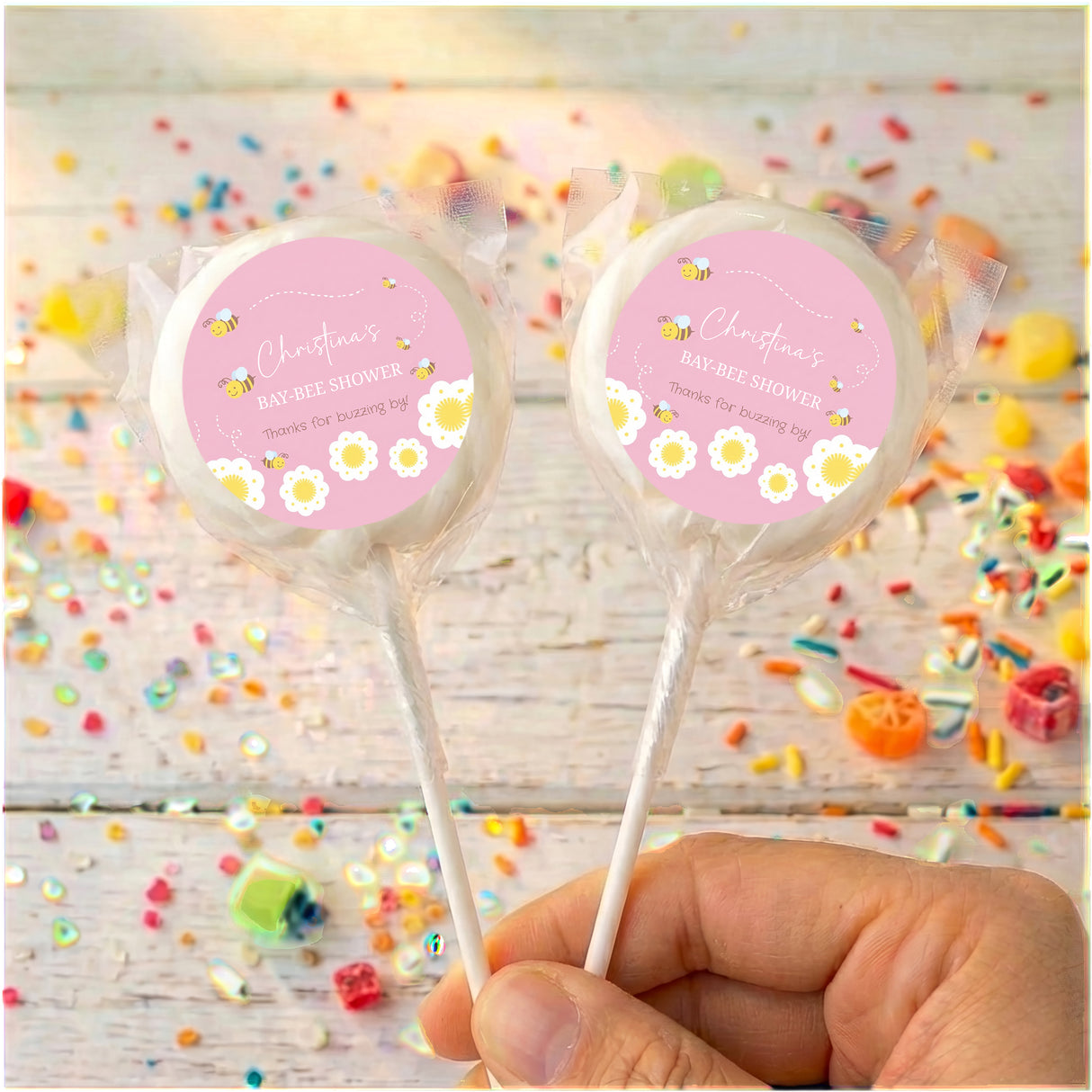 Pink baby shower lollipops with bee design, two wrapped pops with pink circle labels
